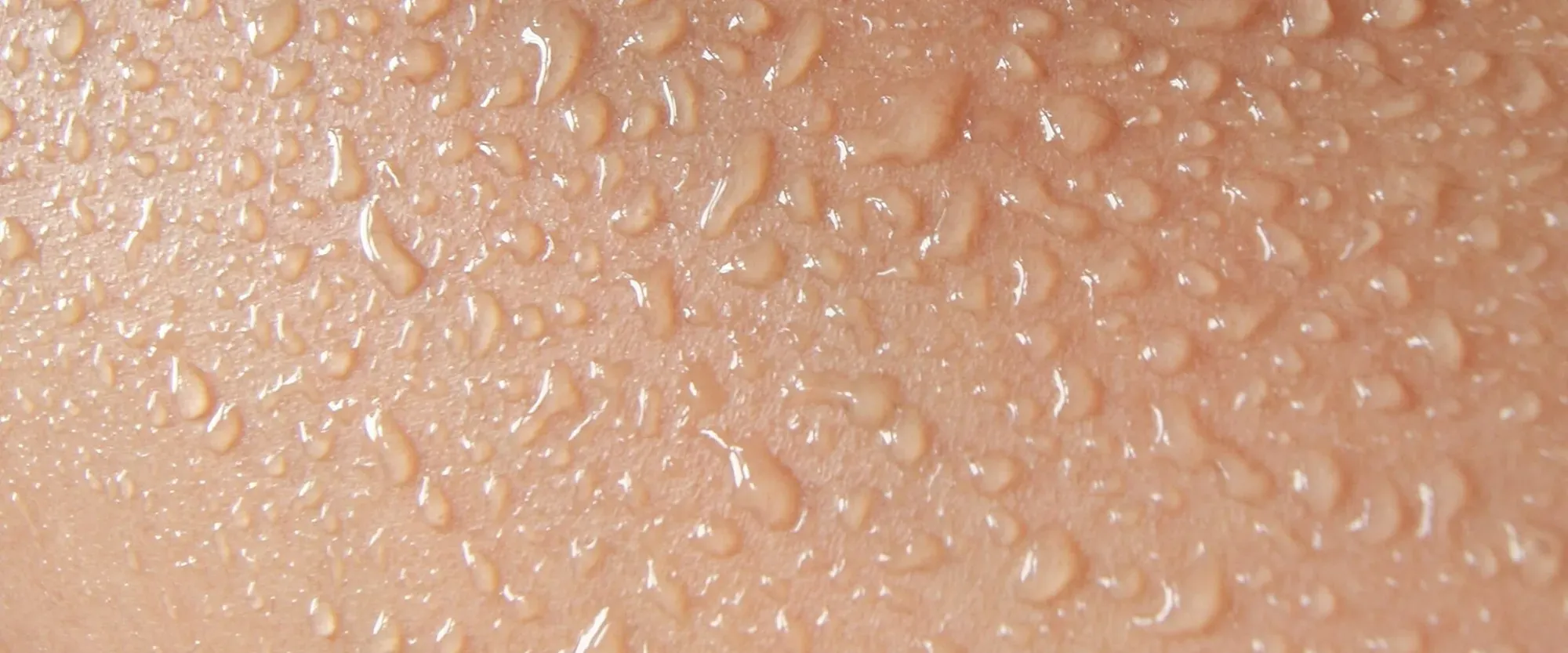 Close-up of skin covered in small drops of water.